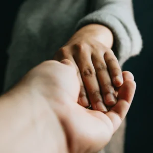Mãos dadas simbolizando apoio, cuidado e solidariedade.