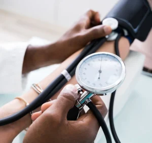 Profissional de saúde medindo a pressão arterial de um paciente.